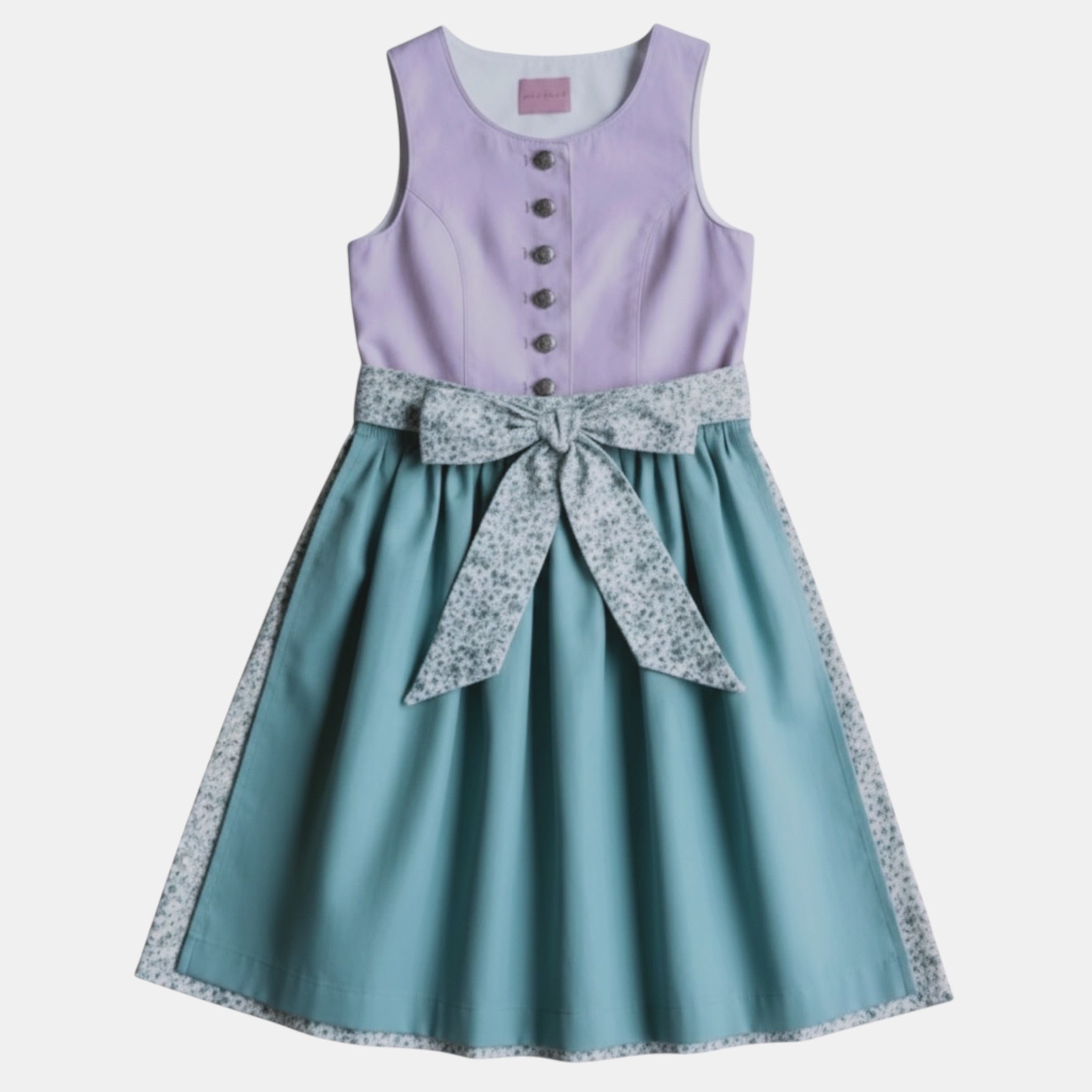 Kinderdirndl fliederfarben mit salbeifarbener Schürze und Blumenrocker vor freigestelltem neutralem Hintergrund