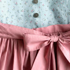 Kinderdirndl hellblau mit altrosa Schürze in Detailansicht
