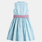 Kinderdirndl hellblau mit altrosa Schürze vor freigestelltem neutralem Hintergrund von hinten