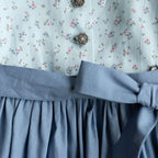 Kinderdirndl hellblau mit blauer Schürze in Detailansicht