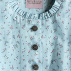 Kinderdirndl hellblau mit blauer Schürze in Detailansicht und Knöpfen